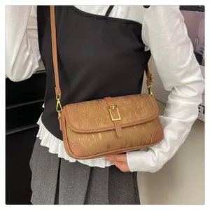 Detail of vintage brown shoulder bag showing wood-texture fabric and gold metal buckle