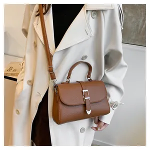 Détail du sac en cuir marron foncé à motif litchi avec une boucle en métal argenté