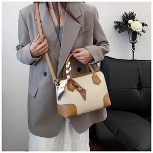 Sac chic en cuir marron et tissage beige porté avec un blazer pour un style moderne