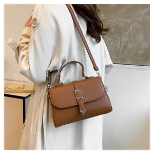 Détail du sac à main marron en cuir grainé avec boucle en métal en forme de cœur