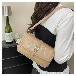 Detail of khaki shoulder bag featuring textured stripes and gold rectangular metal buckle
