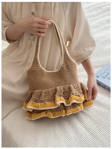 Close-up of handmade knit tote bag featuring tiered yellow and beige ruffled hem details