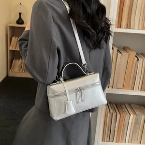 Chic silver rectangular handbag with metallic finish shown in a stylish home office