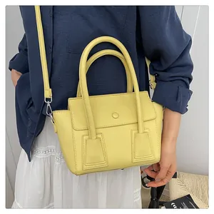 Sac à main jaune en cuir grainé avec boucle ronde et bandoulière réglable chic