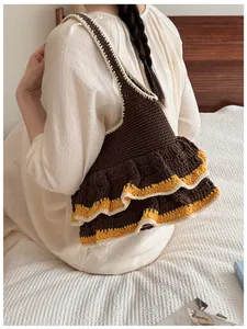 Detail of hand-knitted brown tote bag featuring yellow and white double ruffled edges