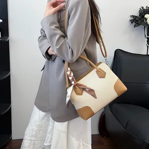 Sac à main tissé beige chic avec bordure en cuir marron et foulard sur mannequin de style