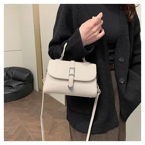 Vue latérale du sac à main en cuir grainé crème avec boucle cœur argentée