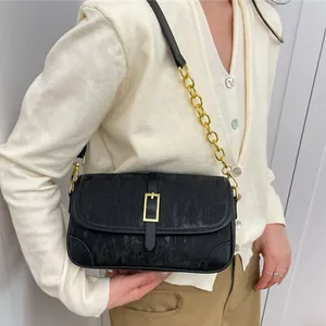 Fashionable black striped crossbody chain bag with gold hardware shown on model