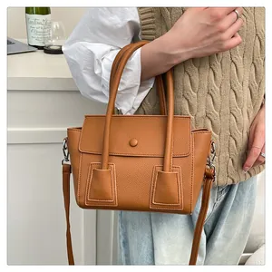 Détail du sac à main en cuir grainé caramel avec double poignée et bandoulière réglable