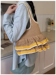 Detail of hand-knitted tote bag featuring yellow ruffle trim and brown crochet texture