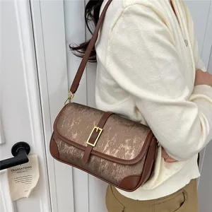 Retro chain crossbody bag with brown metallic texture and gold clasp on a female model