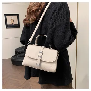 Sac à bandoulière crème chic avec texture litchi et boucle métallique en situation