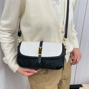Chic black and white striped shoulder bag with gold hardware and adjustable strap