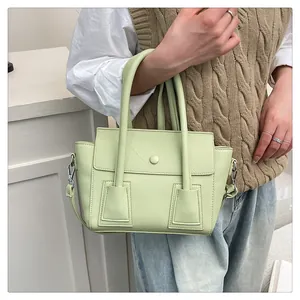 Détail du sac à main vert clair en cuir grainé avec bandoulière amovible et poignées