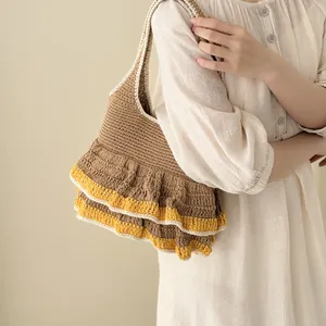 Knitted tote bag with brown crochet texture and yellow ruffle trim detail on beige background