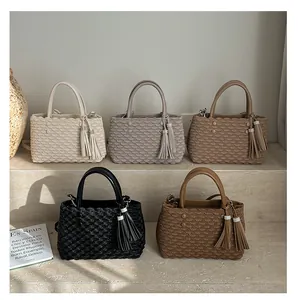 Detailed view of tote bags featuring textured shell patterns and elegant rhinestone tassels