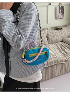 Dettaglio della borsa blu con cerniere gialle a contrasto e tracolla a scacchi