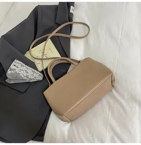 Detail view of khaki PU leather tote bag with neat stitching and woven side decoration