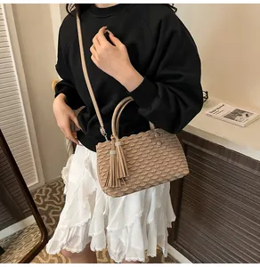 Detailed view of khaki pleated tote bag with fish scale texture and tassel charm