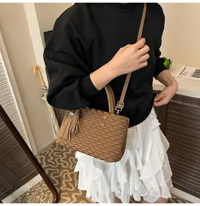 Detail of a brown pleated tote bag featuring long tassel and textured finish