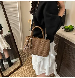 Detail of dark brown tote bag with pleated fish scale texture and tassel accessory
