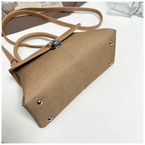 Détail du sac à main en tissu kaki avec clous de protection en métal argenté sur le fond