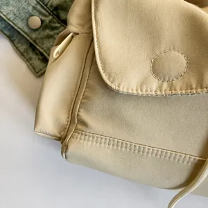 Detaillierte Nahaufnahme der beigen Stofftextur und der hochwertigen Nähte der Tasche