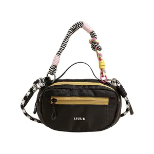 Dettaglio del manico in corda intrecciata colorata e zip gialla su borsa Boston in nylon