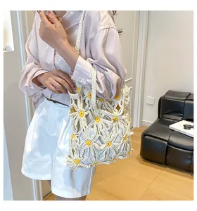 Detail der handgehäkelten Gänseblümchen-Tasche mit weißem Strickmuster und Lochstruktur