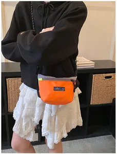 Outdoor-Umhängetasche aus Nylon in Orange und Grau am Modell zur Größendarstellung
