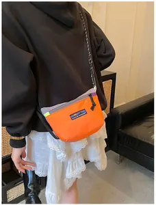 Detailansicht einer orangefarbenen Nylon-Umhängetasche mit violetten und grauen Akzenten