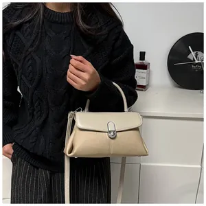 Détail du sac beige et marron avec boucle en métal argenté et tissu texturé élégant