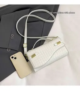 Detail view of woven white leather handbag with golden hardware and size comparison