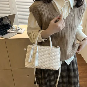 White tote bag with textured ruffles, tassel charms and dual handles for women
