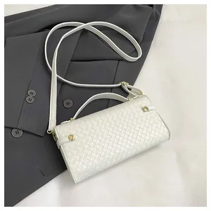 Close-up of white woven leather texture on handbag with golden rivets and strap