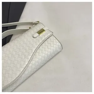 Detail of white woven texture shoulder bag with gold metal buckle and premium leather finish