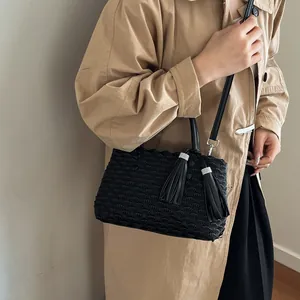 Elegant black pleated tote bag with fish scale texture and fringe tassels on model