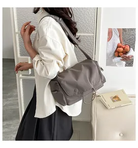 Trageansicht einer minimalistischen taupefarbenen Nylon-Umhängetasche mit breitem Gurt