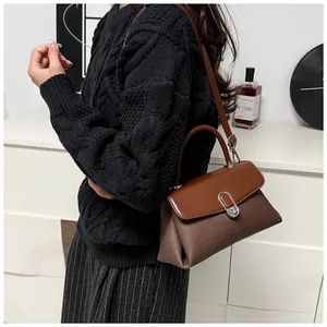 Détail d'un sac à main vintage marron avec un élégant fermoir en métal ovale argenté