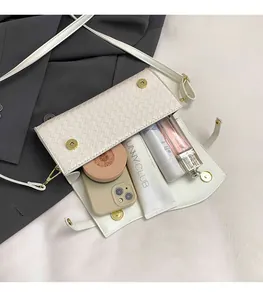 Detail of woven textured crossbody bag interior showing storage for phone and cosmetics