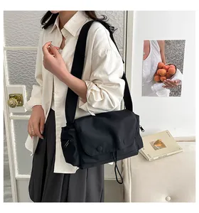 Dettaglio borsa a tracolla in nylon nero con tasca a coulisse e patta di chiusura