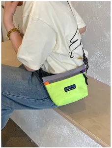 Detail der neongelben Outdoor-Nylontasche mit Kontrastnähten und dem Markenetikett
