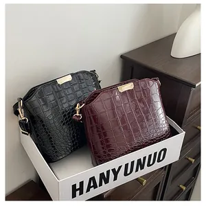 Detailed close-up of glossy crocodile pattern texture in black and burgundy leather