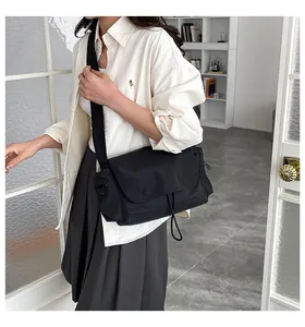 Dettaglio della borsa a tracolla nera in nylon impermeabile con tracolla larga e tasche