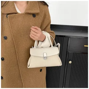 Détail du sac à main en cuir beige avec boucle en métal argenté et poignée supérieure