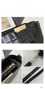 Macro detail of black crocodile embossed leather handbag with premium gold hardware accents