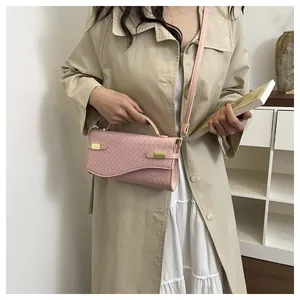 Detailed view of pink woven leather texture and gold buckles on a stylish handbag