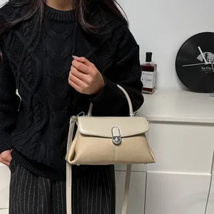 Sac à main bicolore beige et marron avec texture et fermoir rotatif argenté élégant