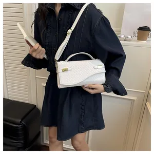 Close-up of white woven leather handbag texture with gold metal buckle and flap detail