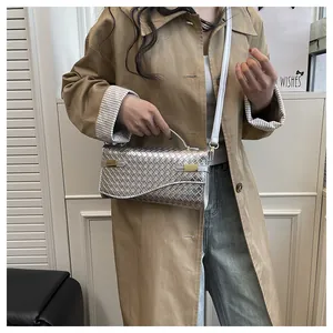 Detail of silver woven texture on shoulder bag with metallic finish and gold hardware